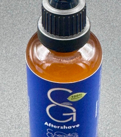 Shea Goodness Aftershave Serum in a dark glass bottle with a pipette dropper for easy and accurate distribution and measurements.